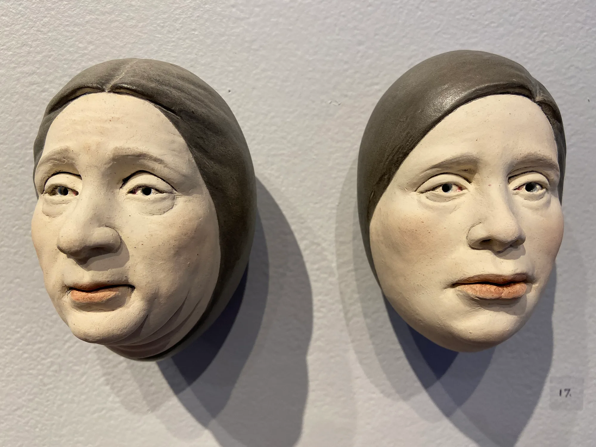 Detail of individual eggheads — ceramic installation by Claudia Olds Goldie