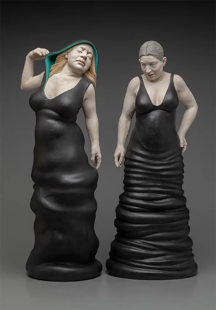 Two figurative ceramic sculptures of women in black gowns by Claudia Olds Goldie